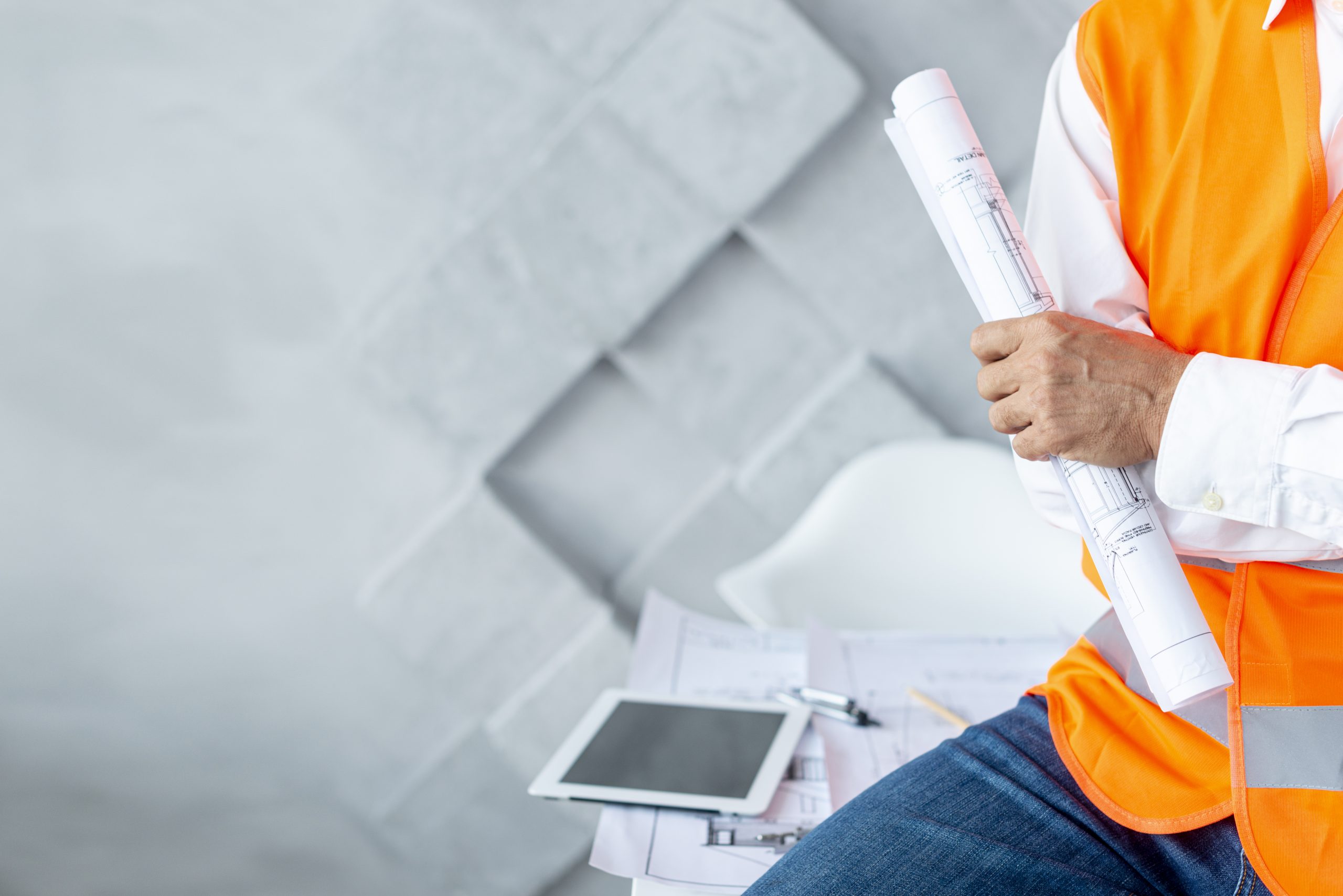 man holding a blueprint and ipad signifying using building information modeling services.