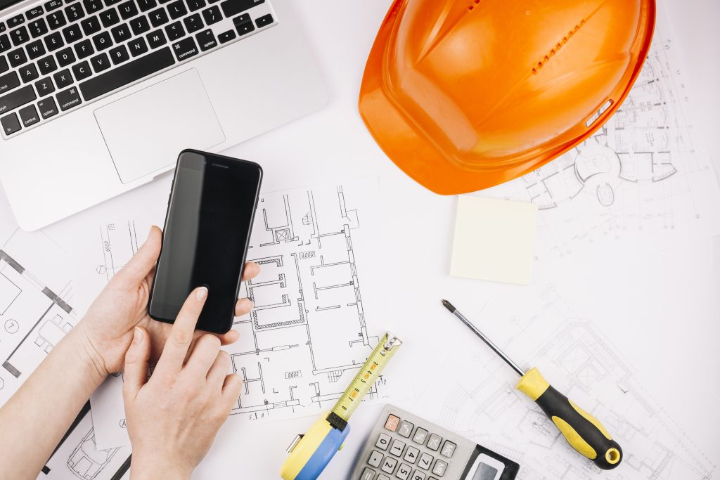 image of a man using building information modeling services on his phone.