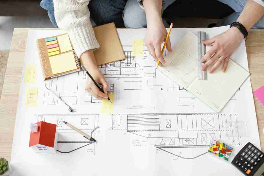man and woman using design drawings for building sketch.