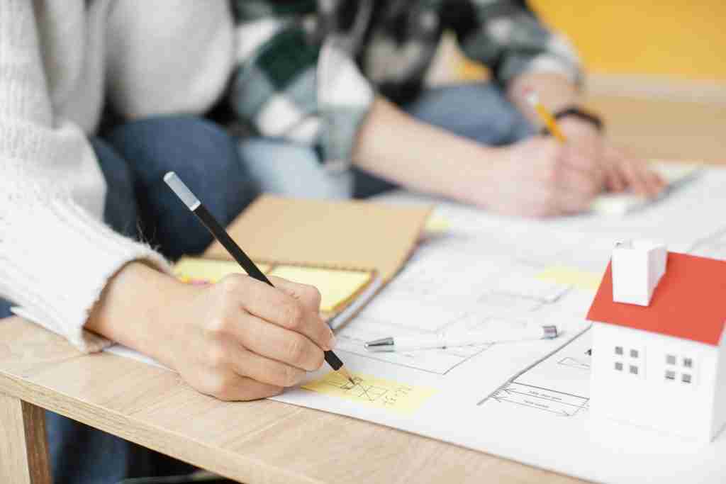 image of man drawing building construction drawings.